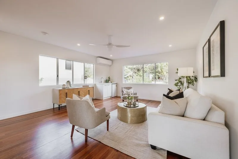 Living room with sofa and armchairs, hardwood floors and windows to the north