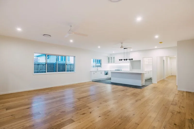 Open plan living and kitchen in the completed Morningside home, with engineered timber floors throughout