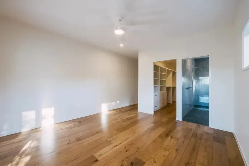 Bedroom with timber floors and an opening through to the walk-in robe