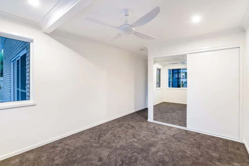 Carpeted bedroom with sliding doors through to the adjoining room