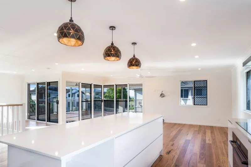 Kitchen island looking out through sliding doors to the deck and the bay beyond