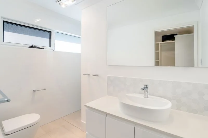Bathroom with a vessel basin on a floating vanity and a full-width mirror