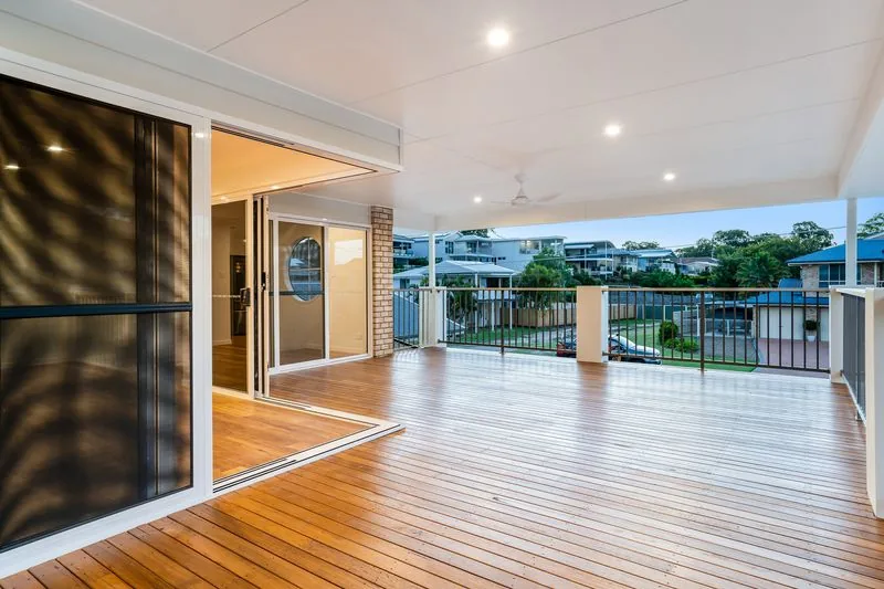 New timber deck opening off the living area, with sliding doors and an outlook over the neighbouring rooftops